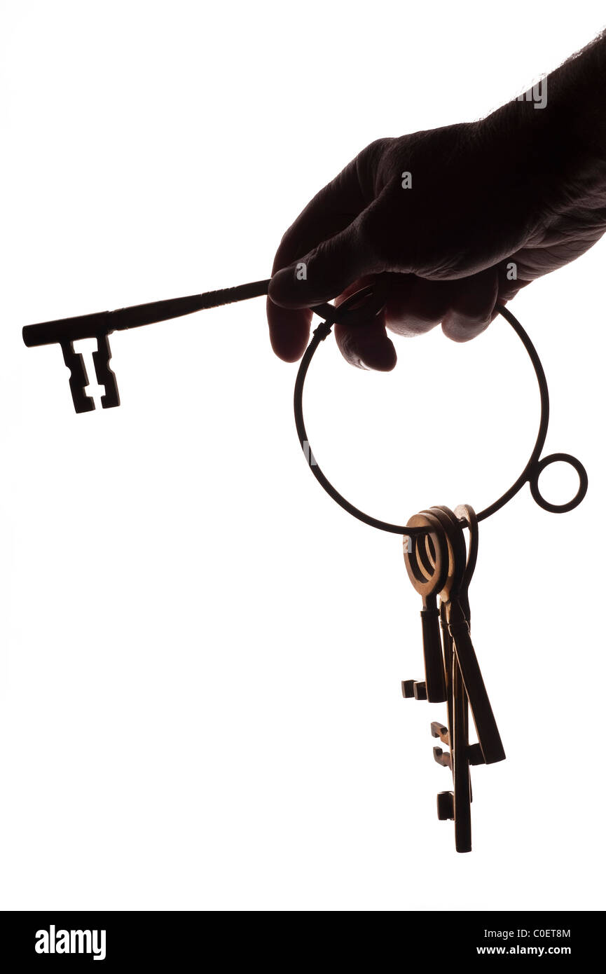 Hand holding a set of large keys on a white background Stock Photo - Alamy