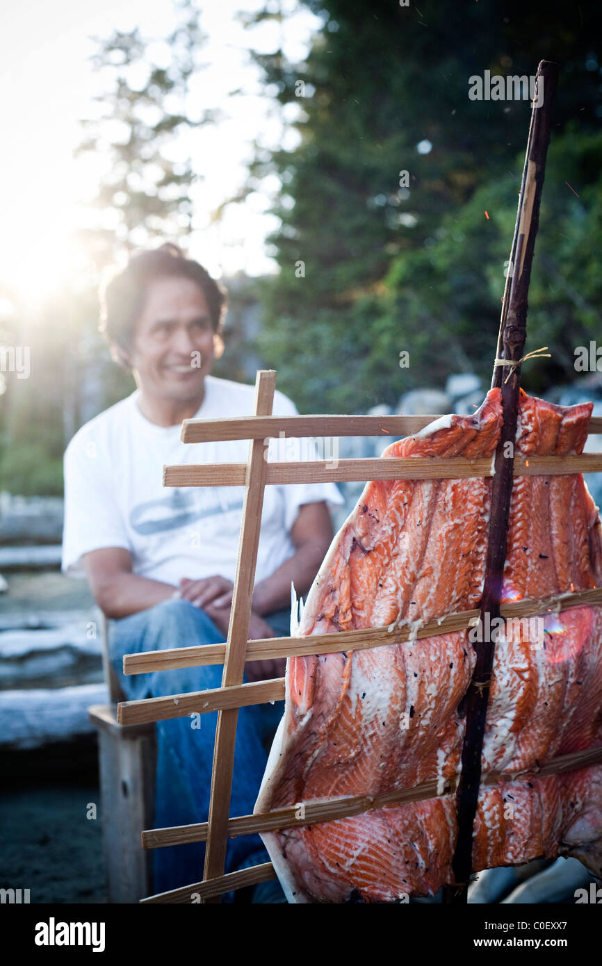 Salmon cooks in the native people style over an open flame. Stock Photo