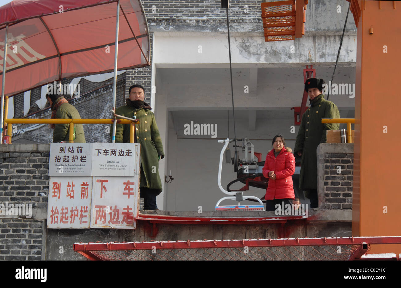 Chair lift attendants at Mutianyu, The Great Wall of China, prepare to help passengers disembark. Stock Photo