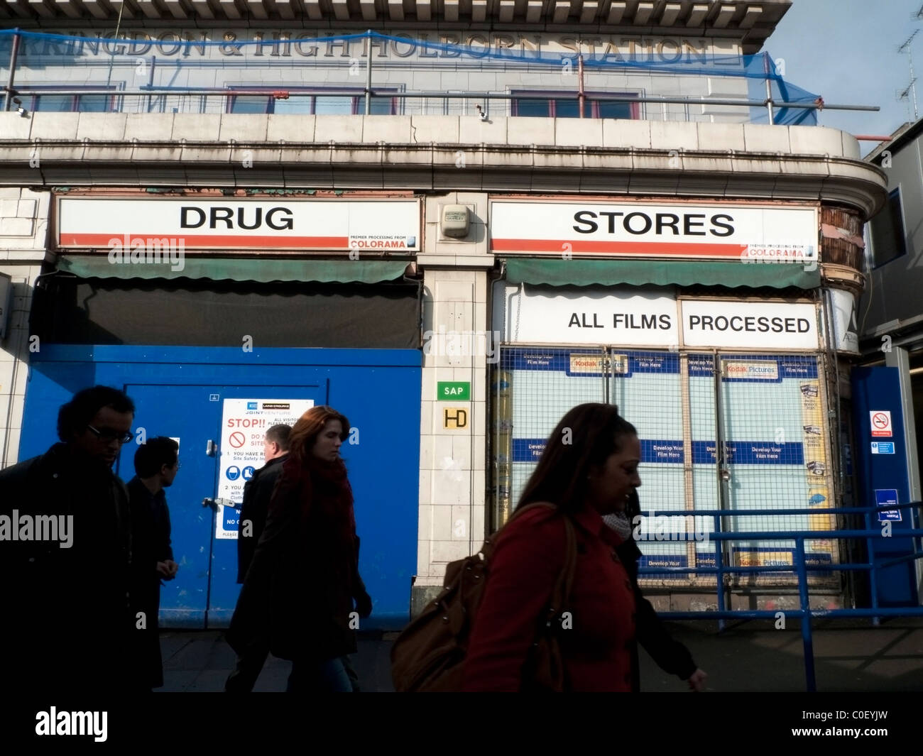 Office workers walking past a chemist's store outside with Drug Store
