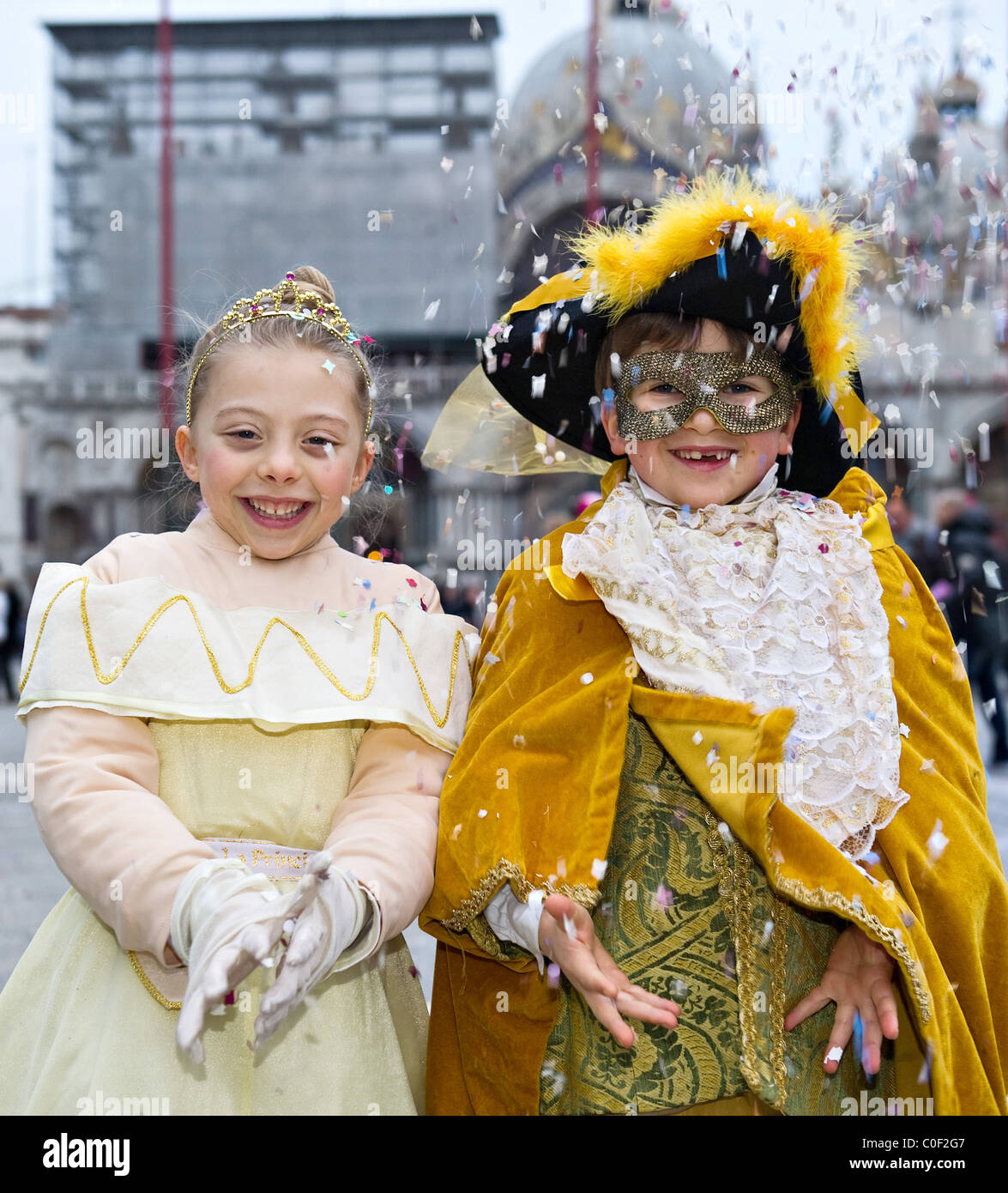 Two children wearing Carnival costumes in St Mark Square Venice Italy