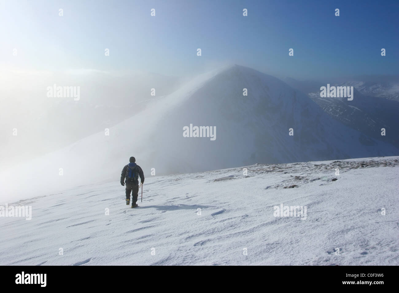 Hiker heading to Stob Coire Easian as the mist clears from Stob a'Choire Mheadhoin. Stock Photo