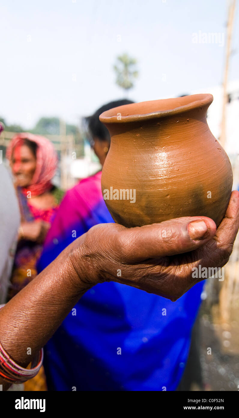 A woman holding a small clay pot on the bank of the Ganges river in Bihar. Stock Photo