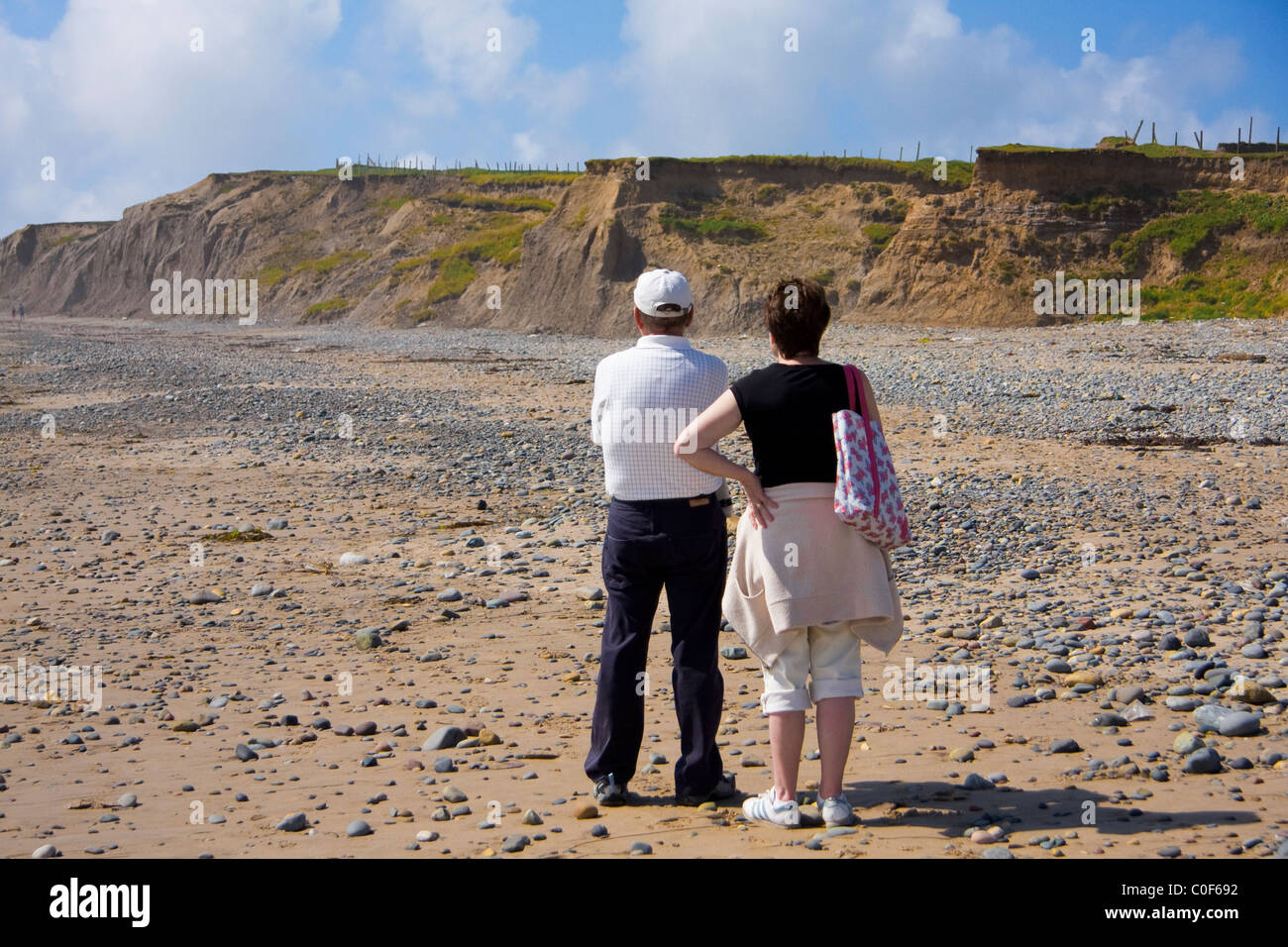 Couple at the beach looking at the hill Stock Photo