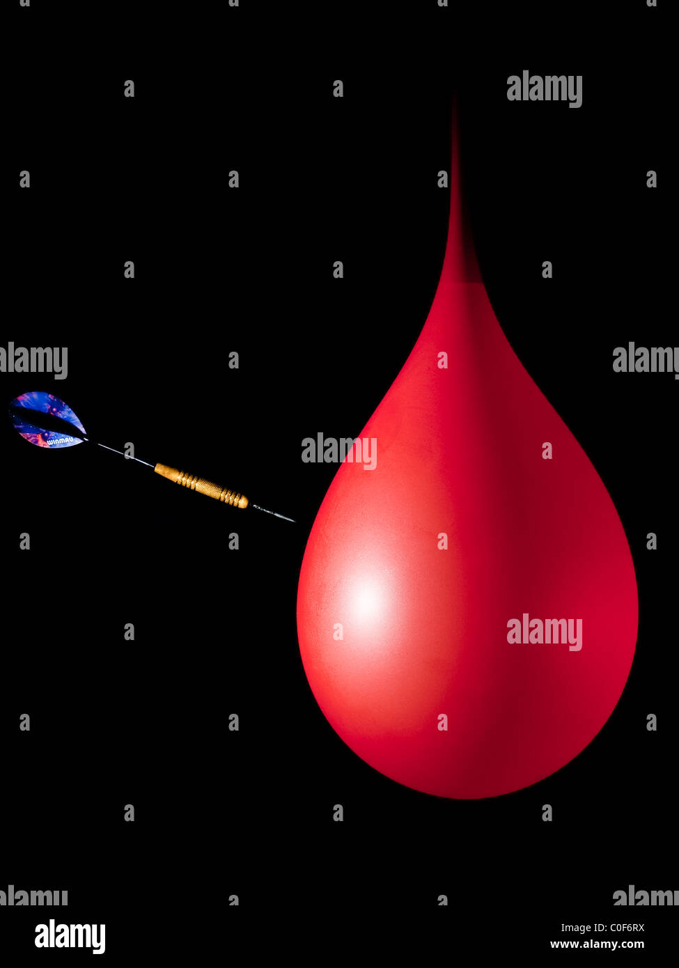 One image of a sequence showing high speed flash photography using a dart bursting a balloon filled with water. Stock Photo