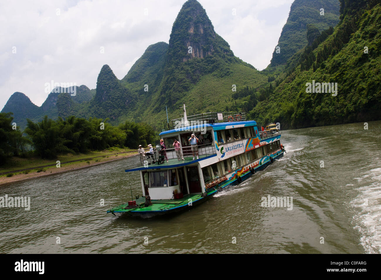 Boat with tourists going down the Li river part with the karts formation of the image used on the 20 Yuan note Stock Photo
