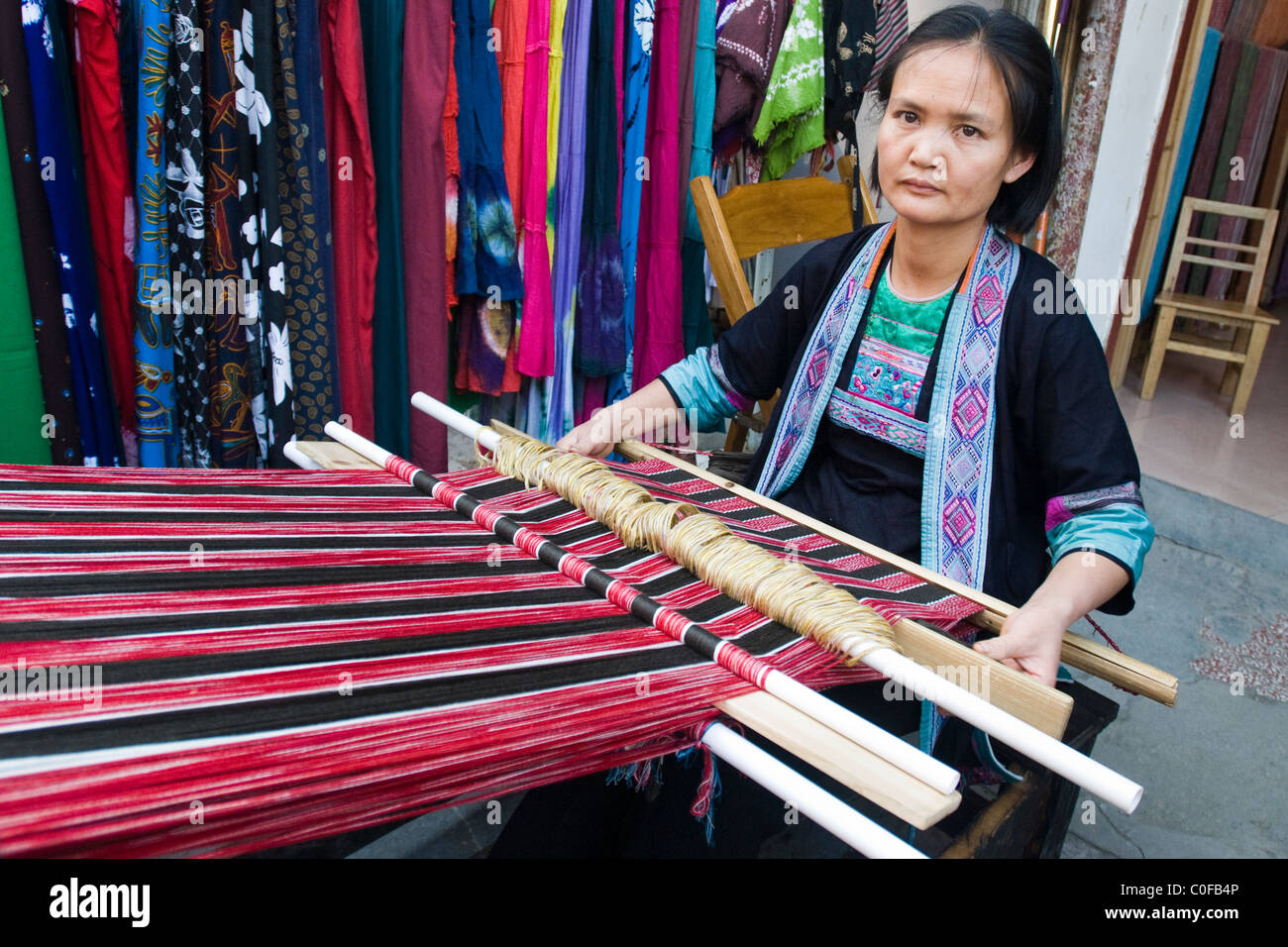 Guanxi  minority woman making a traditional textile on a wooden loom. Stock Photo