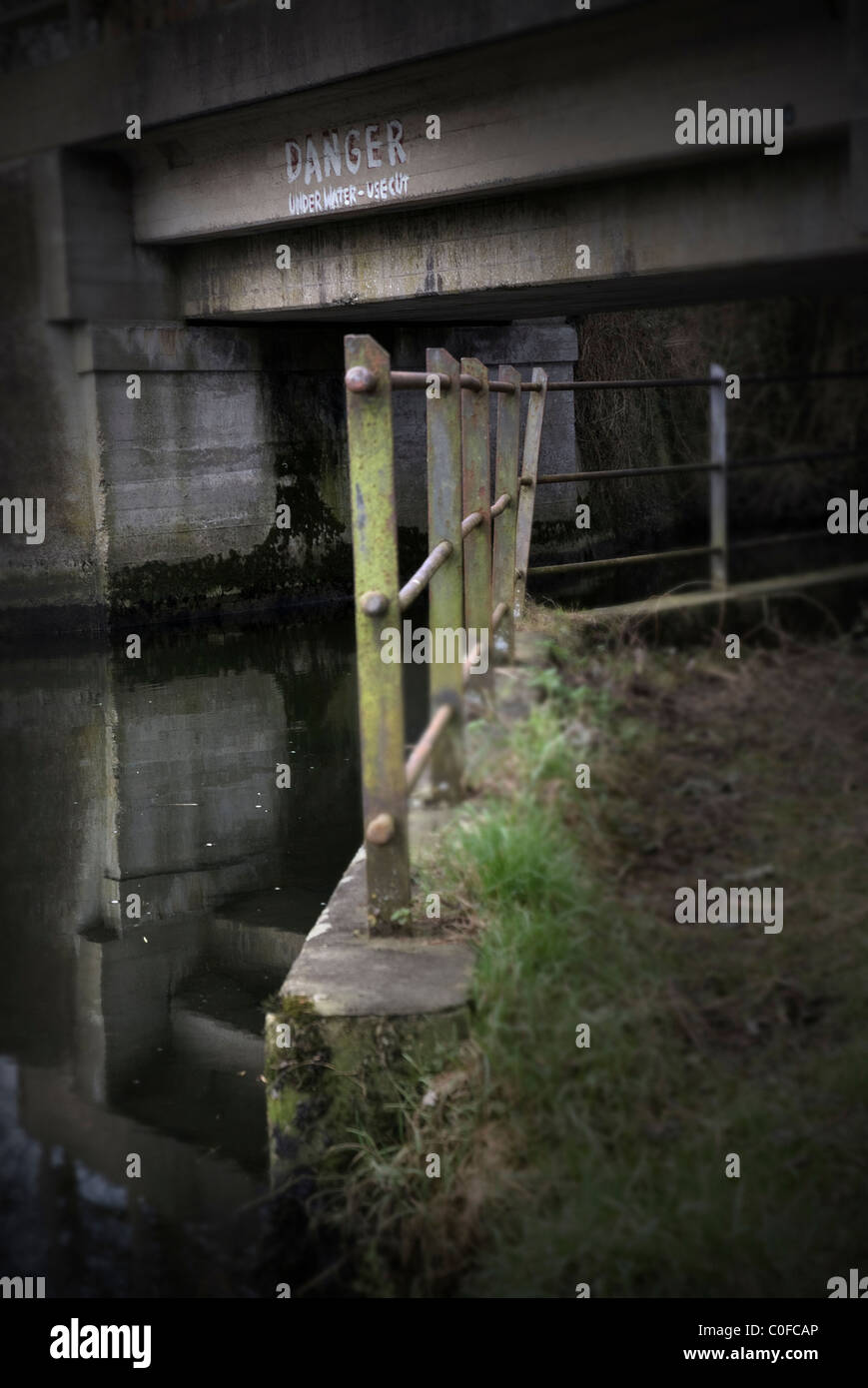 iron railings beside water under bridge Stock Photo