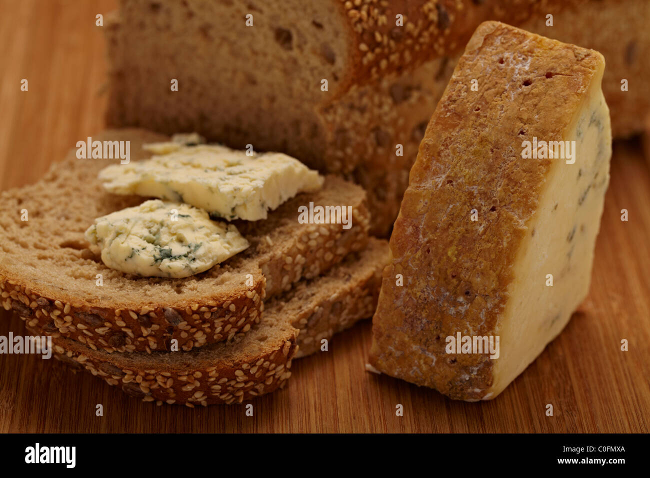 Freshly baked bread with stilton cheese on a bamboo chopping board Stock Photo