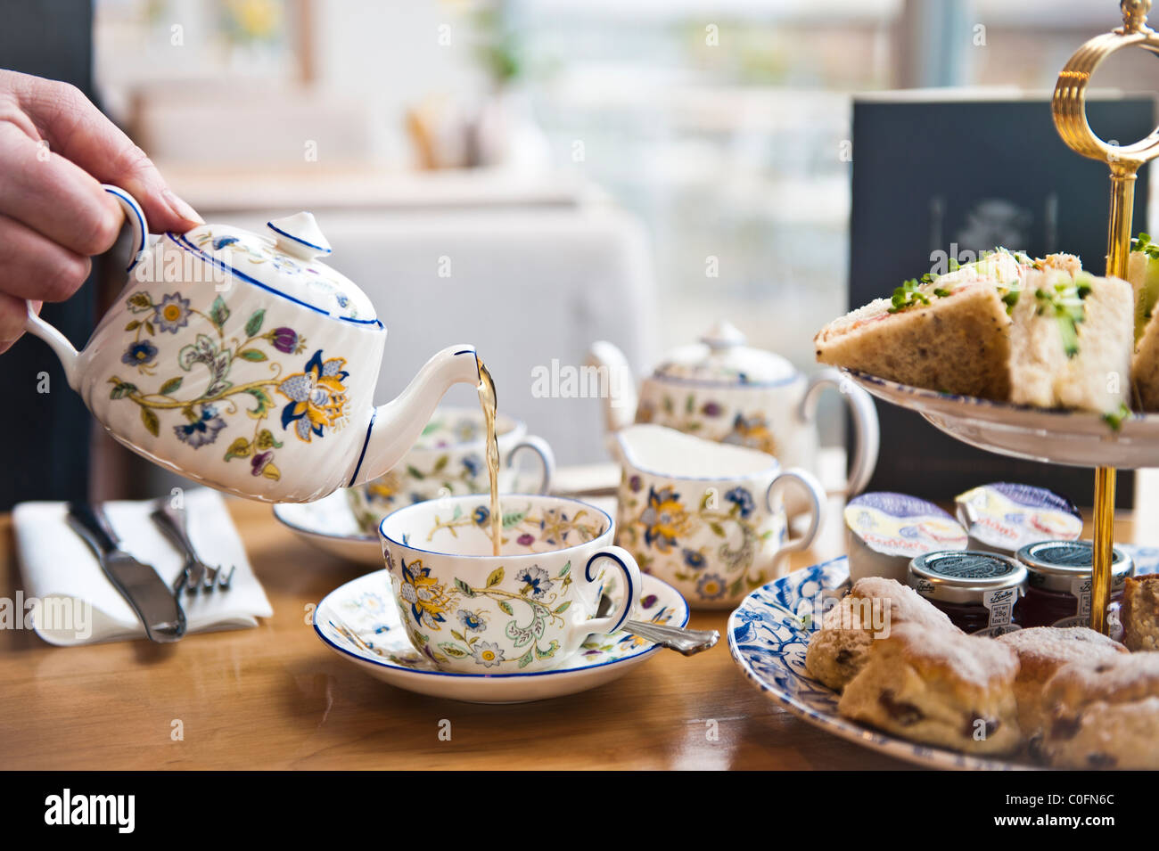 Typical English tea being poured from teapot Stock Photo