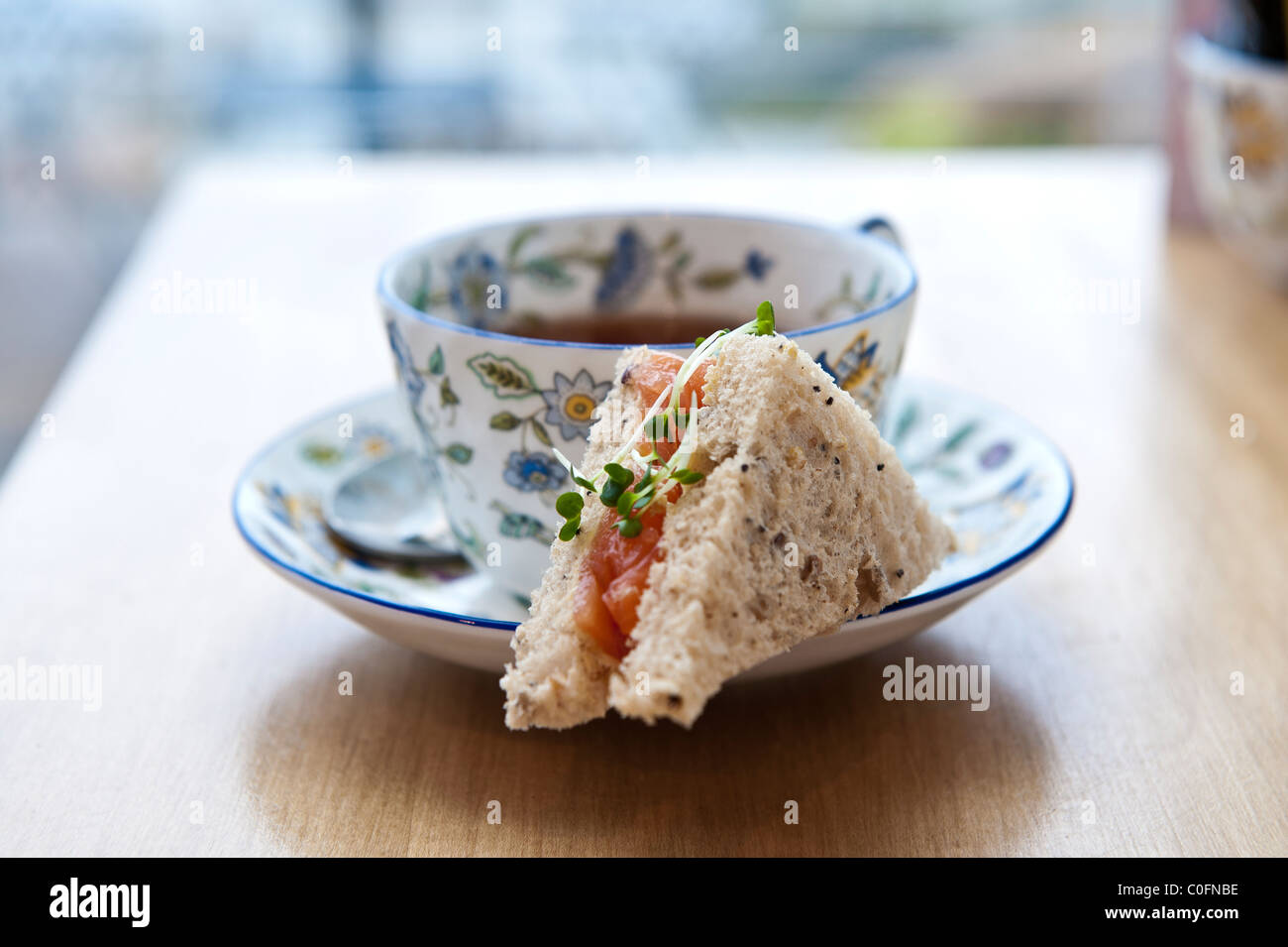 English cup of afternoon tea with smoked salmon sandwich Stock Photo