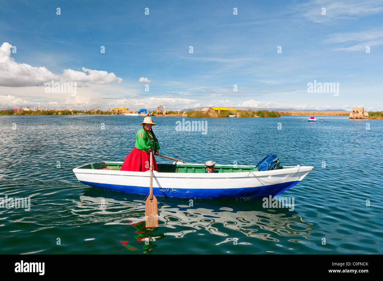 A woman rowing a boat at the floating Islands in Lake Titicaca, Peru, South America. Stock Photo