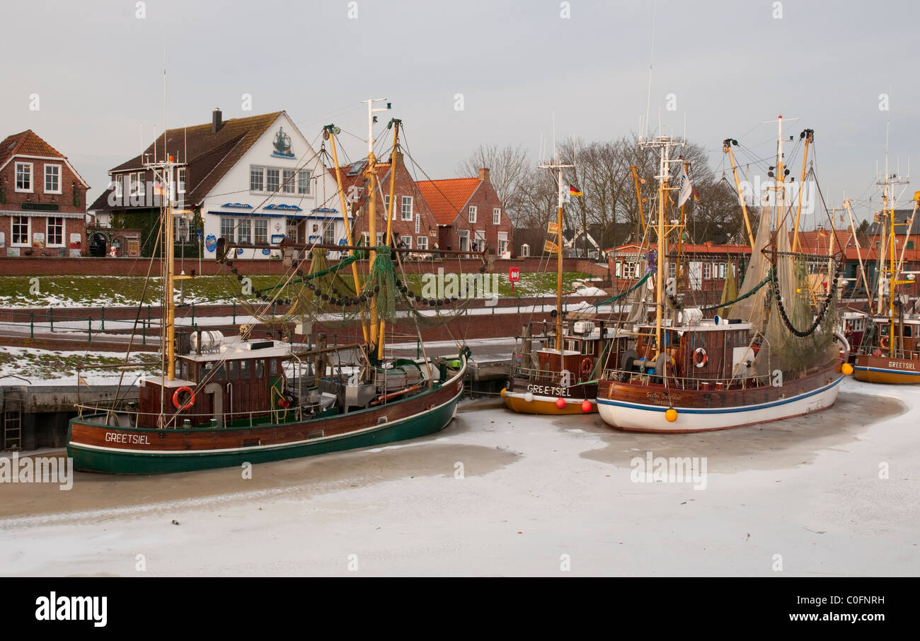 Greetsiel, harbour with shrimp cutters and dike, winterview Stock Photo
