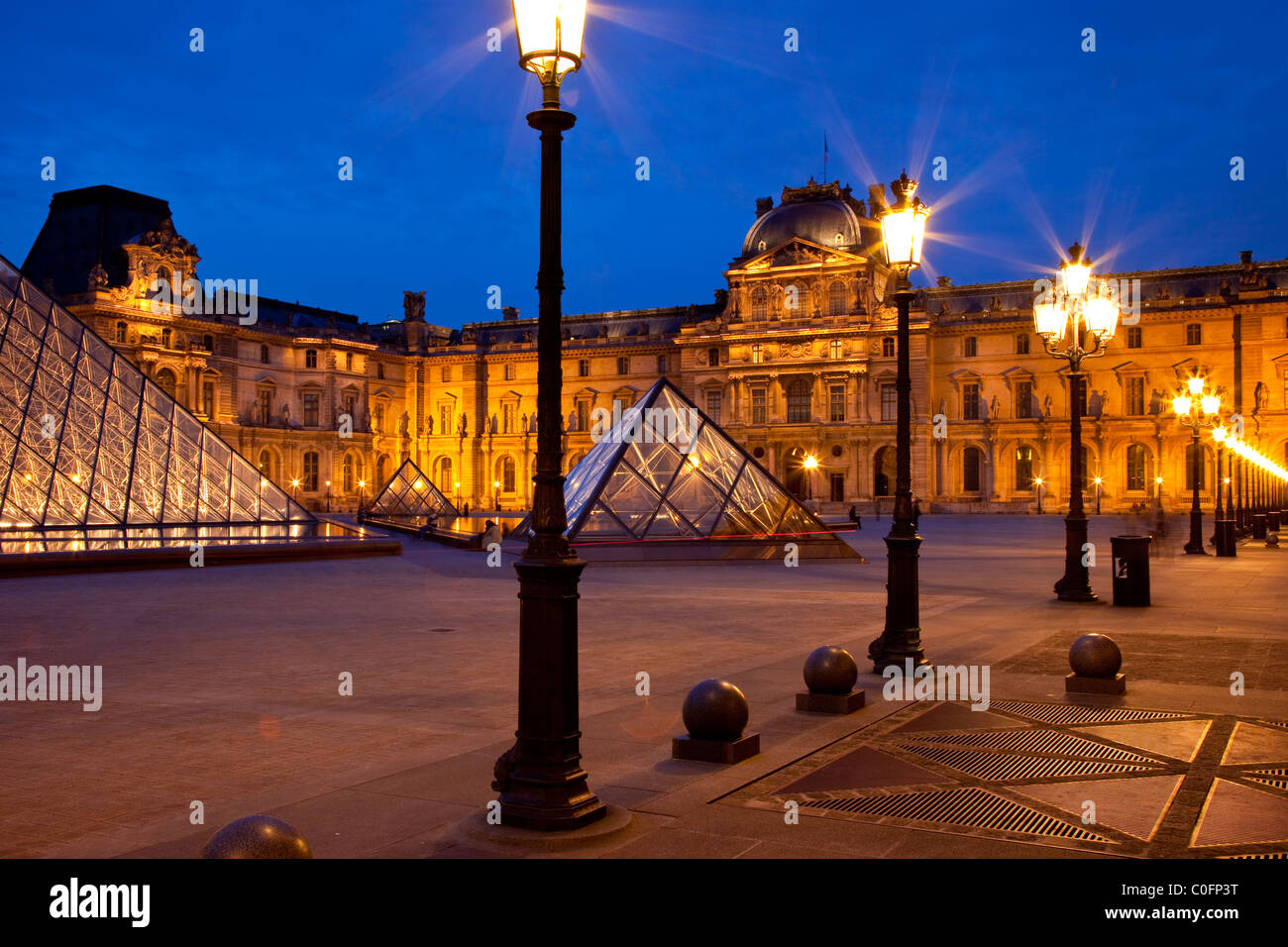 Lighted courtyard of Musee du Louvre at twilight, Paris France Stock Photo