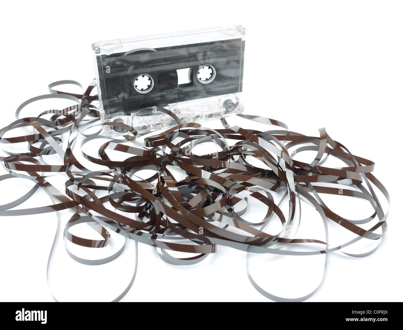 Old audio cassette tape pulled out and tangled on white background Stock Photo