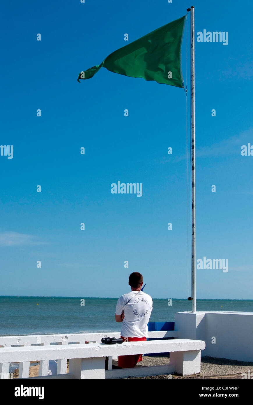 French Life Guard on duty watching swimmers at the beach at La Tranche-Sur-Mer on a beautiful Summers day Stock Photo