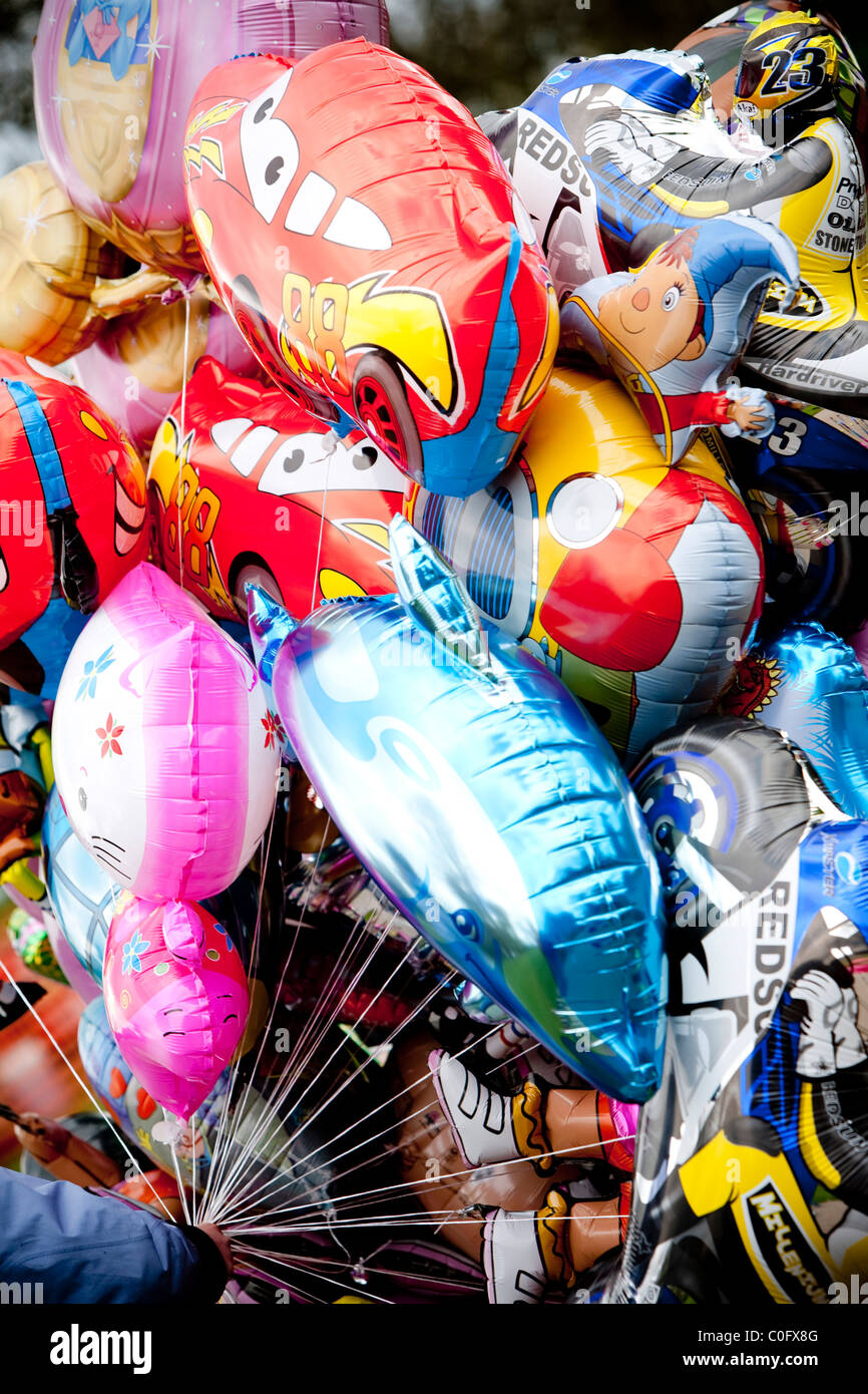 Helium balloon animals and cars held in a hand hires stock photography