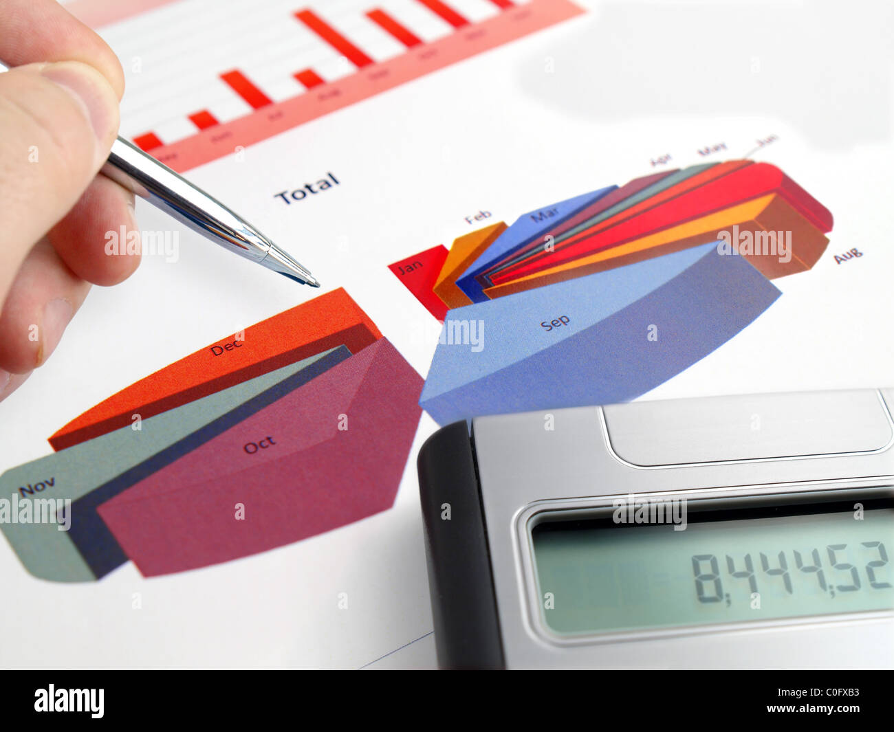 Male hand with pen on pie investment chart with calculator Stock Photo