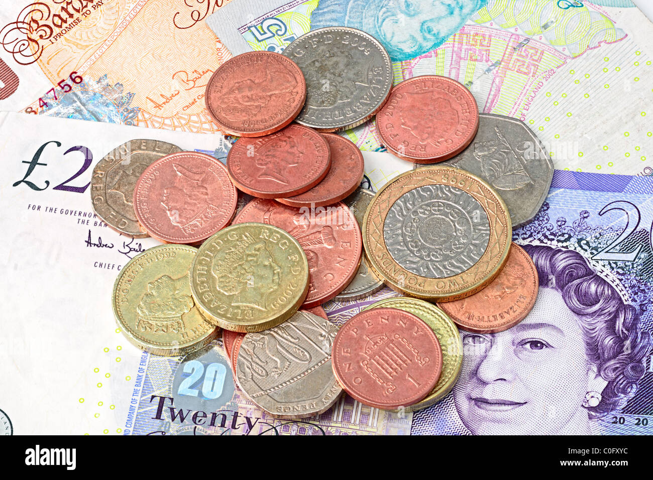 Selection of contemporary British coins, on British banknote background Stock Photo