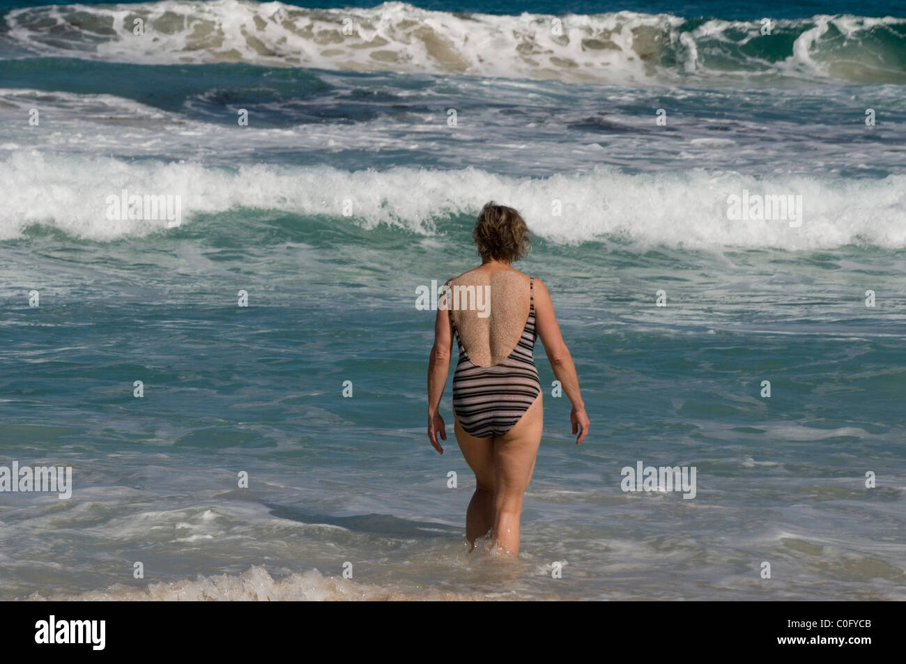 Woman entering the surf near Margaret River, Southwest Western Australia Stock Photo