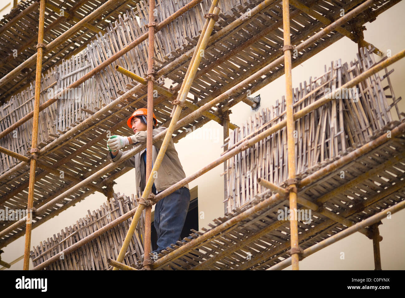 Worker in traditional Chinese scaffolding, Shanghai, China Stock Photo