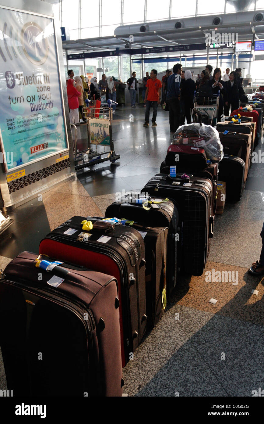 A row of bags at the Kuala Lumpur International Airport check-in counter - Malaysia. Stock Photo
