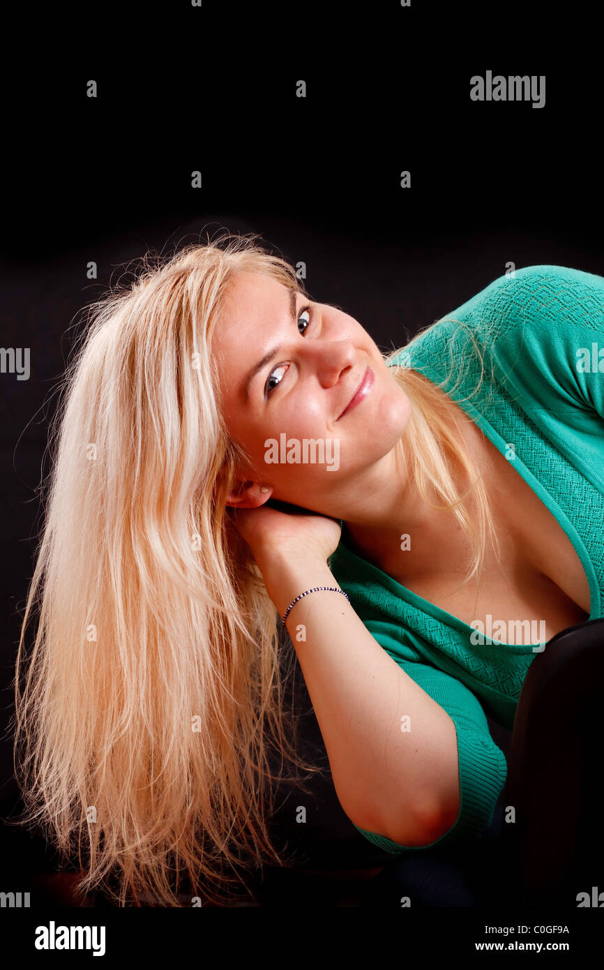 Long blond hair. Caucasian girl isolated on black background. Stock Photo
