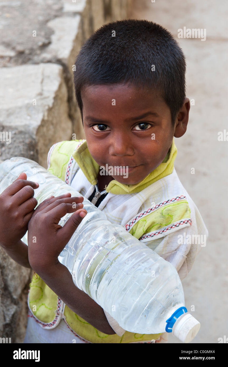 Indian boy carrying water bottle hi-res stock photography and