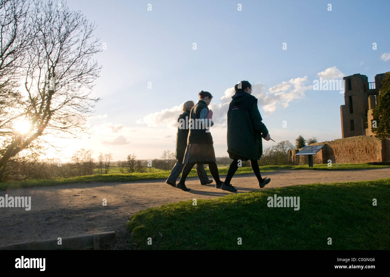 English Heritage workers stroll into Kenilworth Castle at closing time. Stock Photo