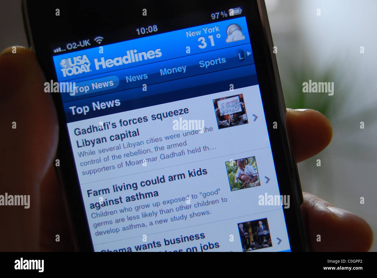 A photo illustration of a person holding an iphone 3gs, showing the USA Today News content provider app Stock Photo