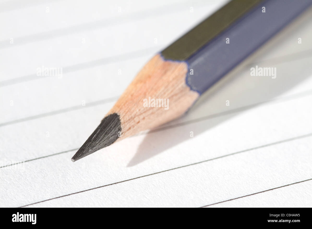 A sharpened pencil on a white lined piece of paper Stock Photo