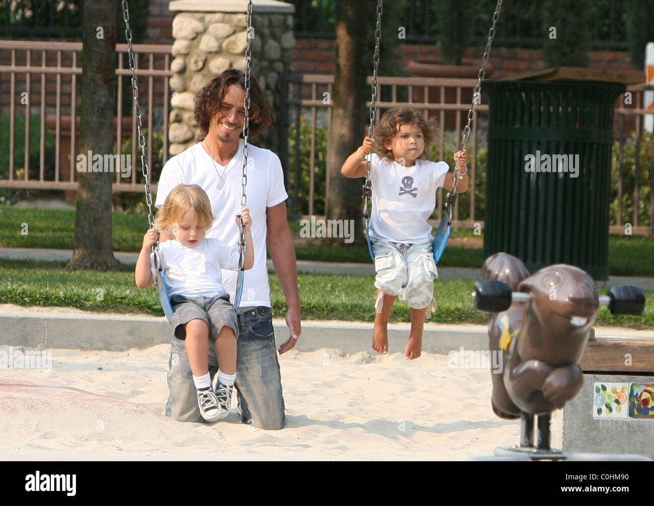Chris Cornell, his son Christopher and daughter Toni playing on the swings as the musician spent some quality time with his two Stock Photo