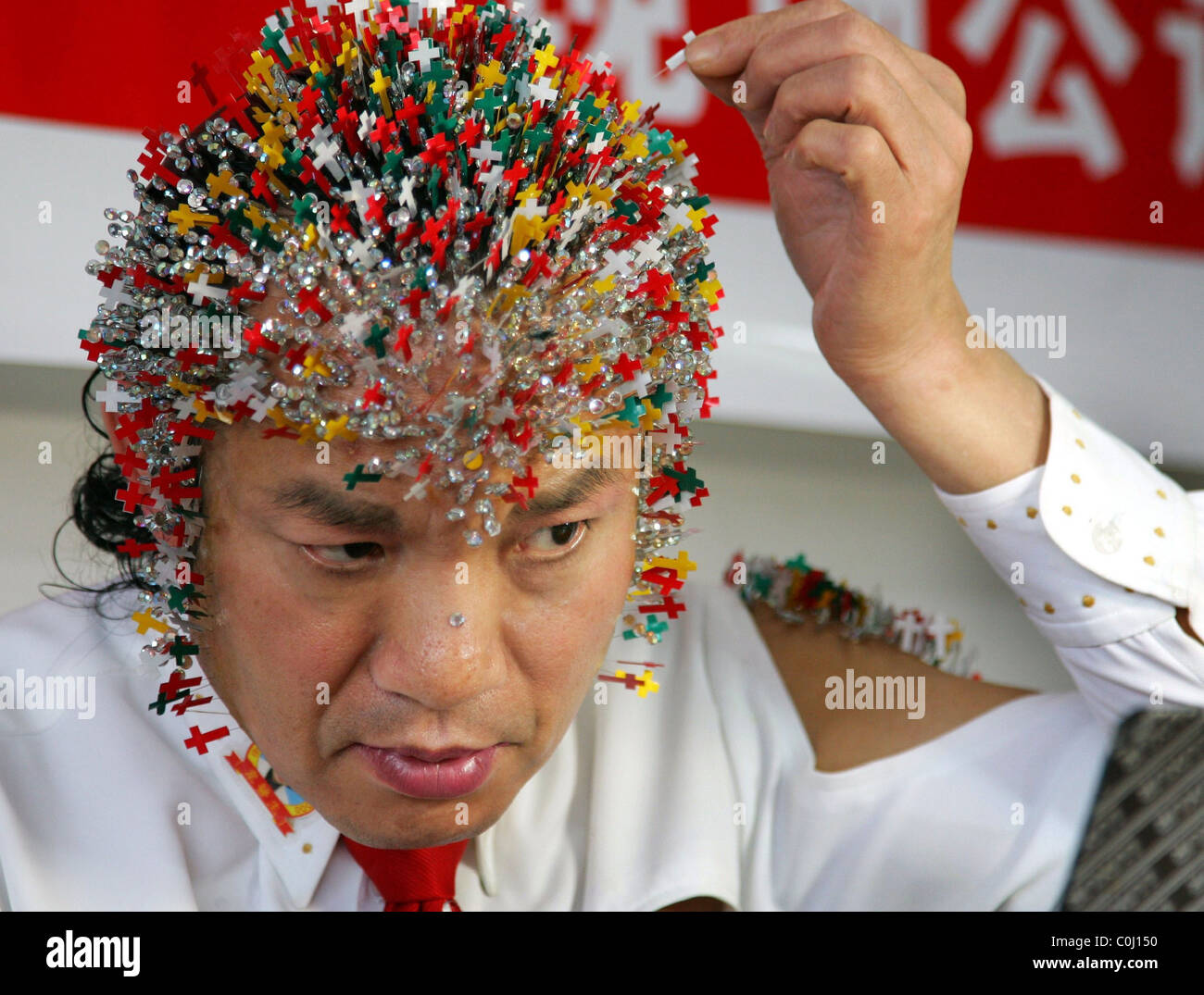 RECORD BREAKER GETS THE NEEDLE For any normal person, this stunt would be a  right pain - but not for Wei Shengchu. Shengchu Stock Photo - Alamy