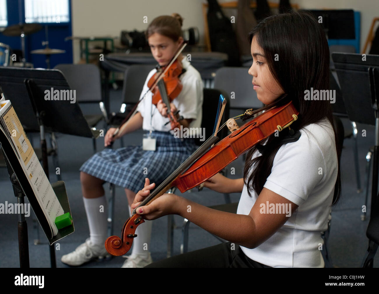 Middle school girls practice violin during orchestra class at the Ann
