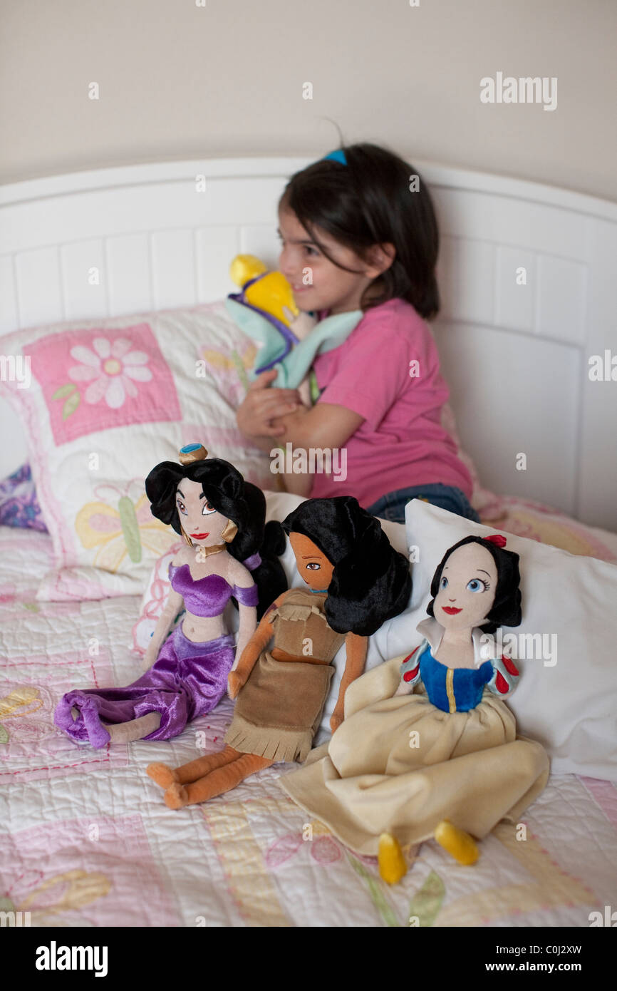 5-year-old Mexican-American girl plays with her Disney character dolls Snow White, Princess Jasmine, Pocahontas, Tinker Bell Stock Photo