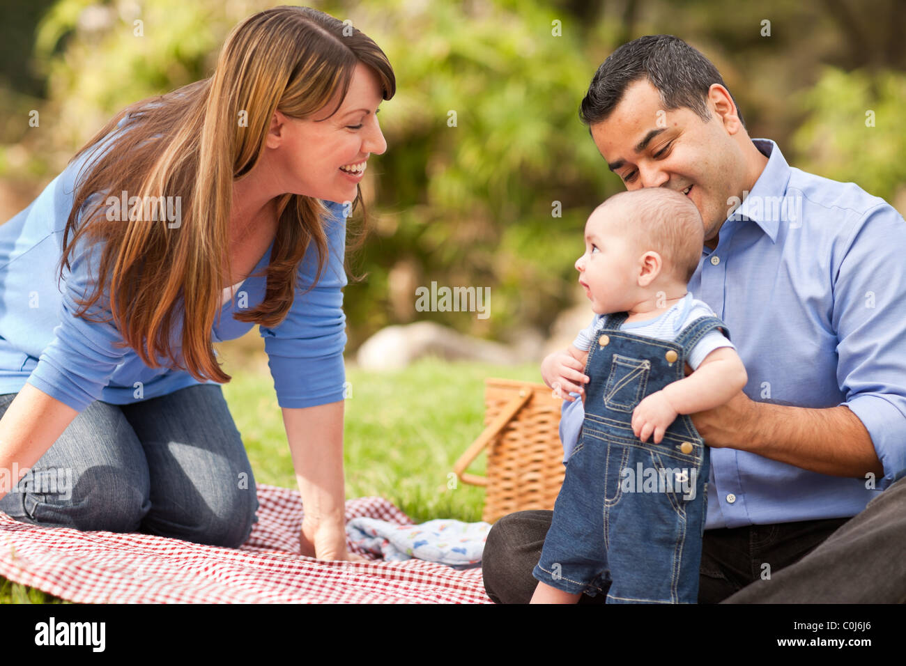Happy Mixed Race Family Having a Picnic and Playing In The Park Stock ...