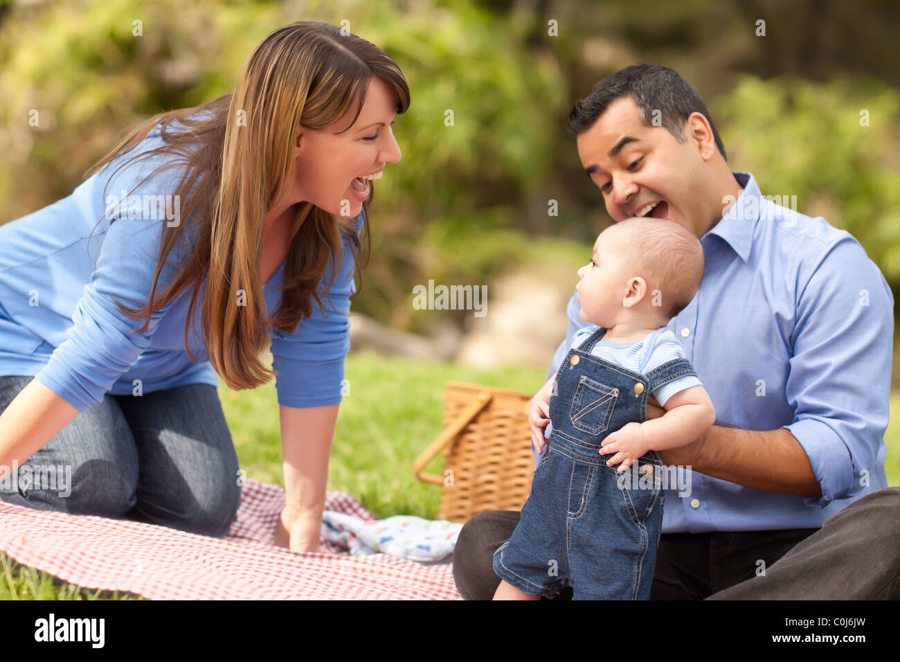 Happy Mixed Race Family Having a Picnic and Playing In The Park Stock ...
