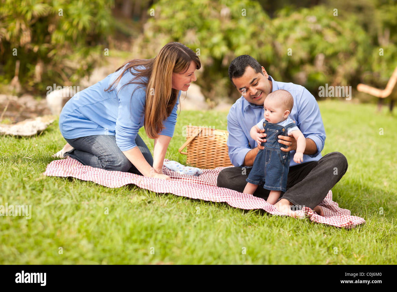 Happy Mixed Race Family Having a Picnic and Playing In The Park Stock ...