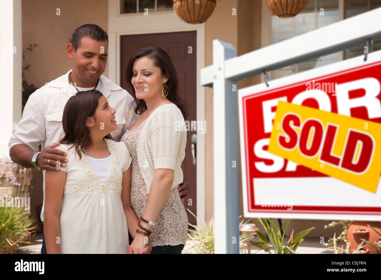 Hispanic Mother, Father and Daughter in Front of Their New Home with ...