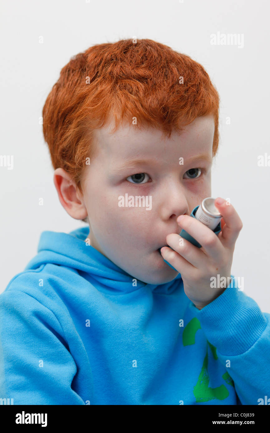 Little boy using his asthma inhaler to alleviate symptoms. Stock Photo