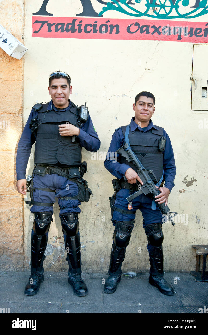 two Oaxacan municipal policemen in uniform wearing bulletproof vests shin guards &  impressive guns Oaxaca Mexico Stock Photo