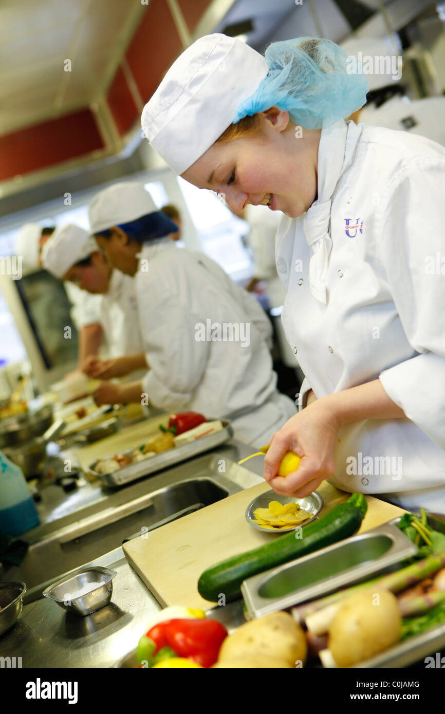 Student chefs learning to prepare food in a kitchen at Birmingham college, Stock Photo
