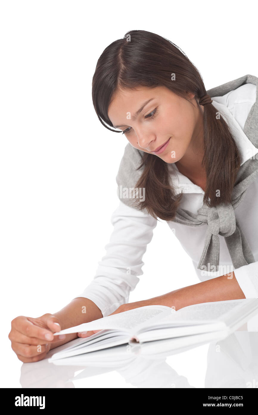 Teenager reading book and lying down on white background Stock Photo ...