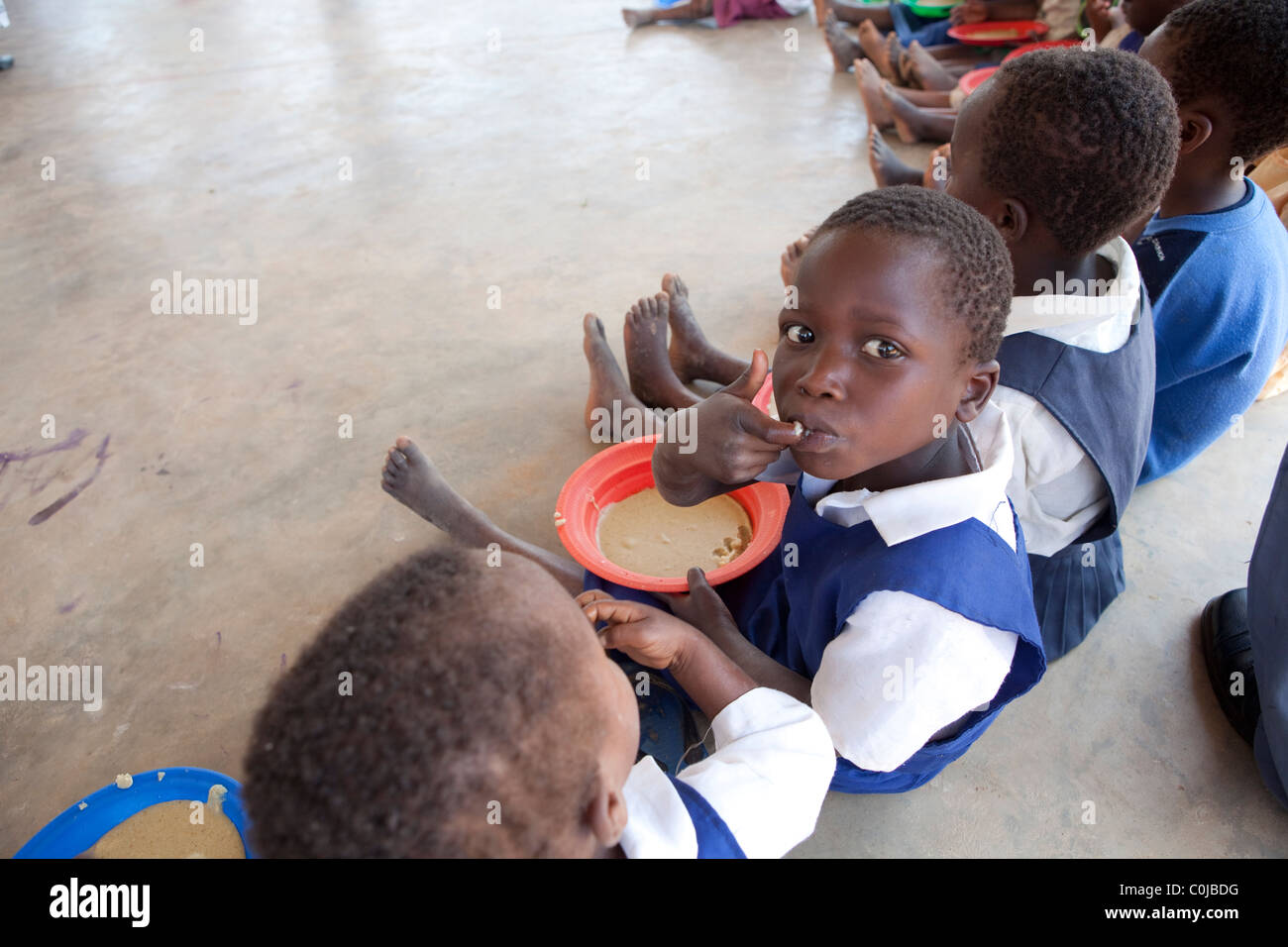 Children eat a meal at a centre for orphans and vulnerable children funded by UNICEF in Mchinzi, Malawi, Southern Africa. Stock Photo