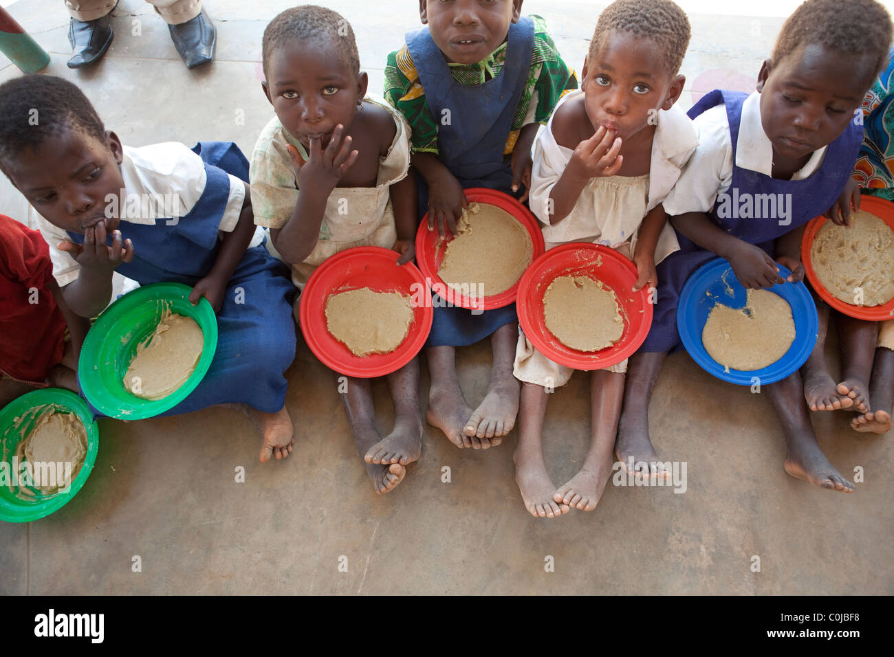Children eat a meal at a centre for orphans and vulnerable children funded by UNICEF in Mchinzi, Malawi, Southern Africa. Stock Photo