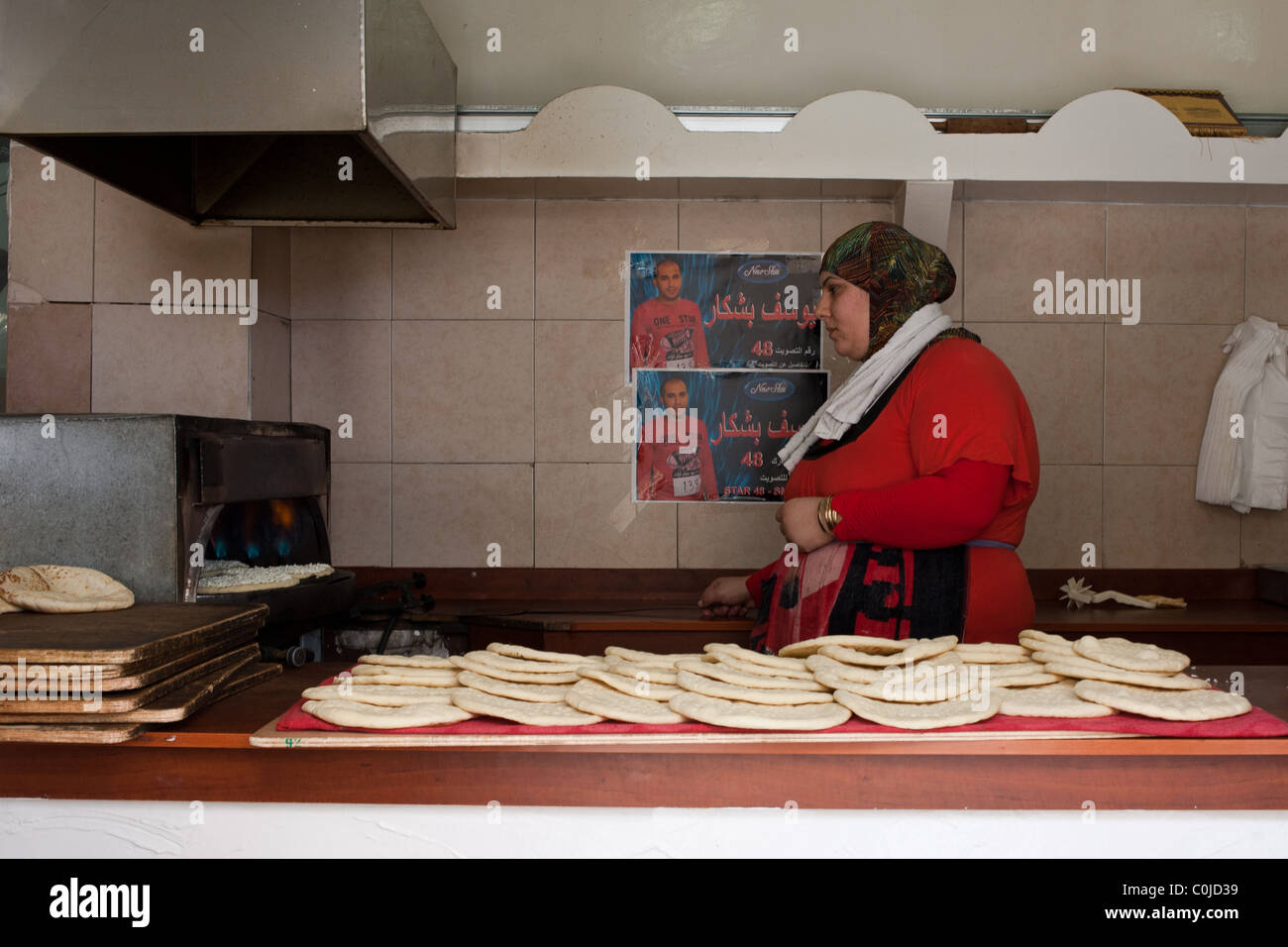 Female Arab baker preparing pita bread in oven Stock Photo Alamy