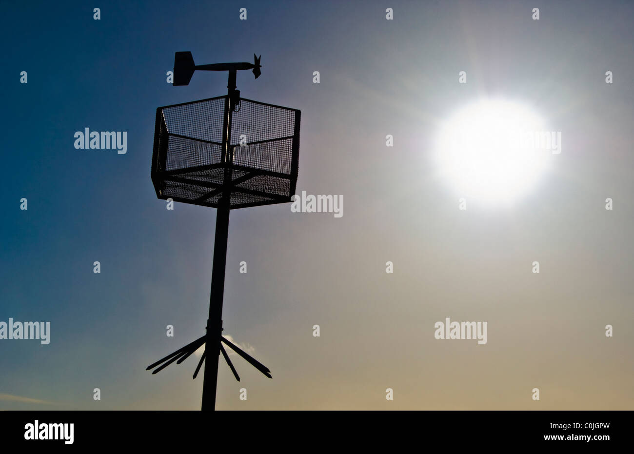 An Anemometer measuring wind speed set against a bright sun. Stock Photo