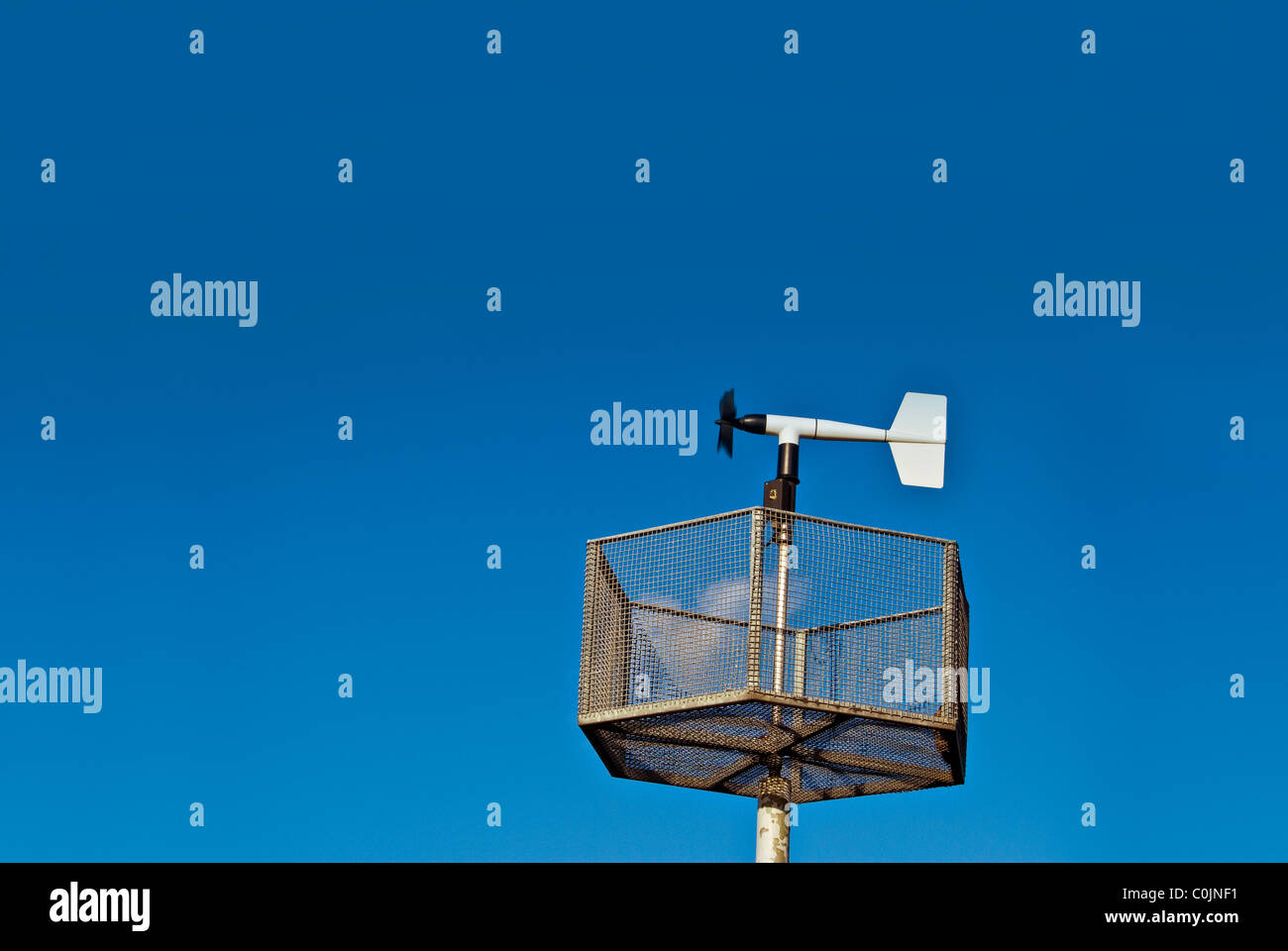 An Anemometer measuring wind speed set against a blue sky. Stock Photo