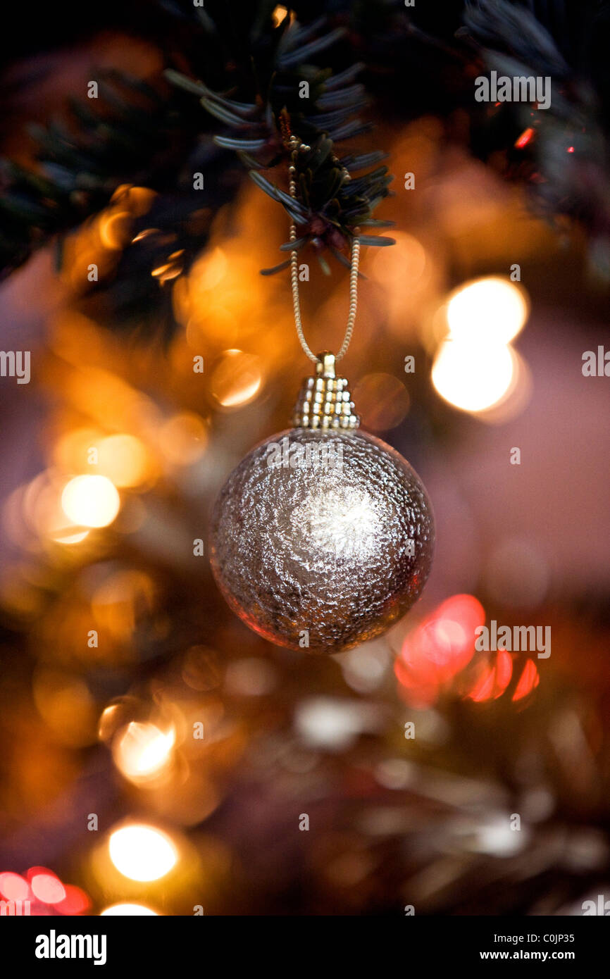 A gold bauble hanging on a Christmas tree Stock Photo