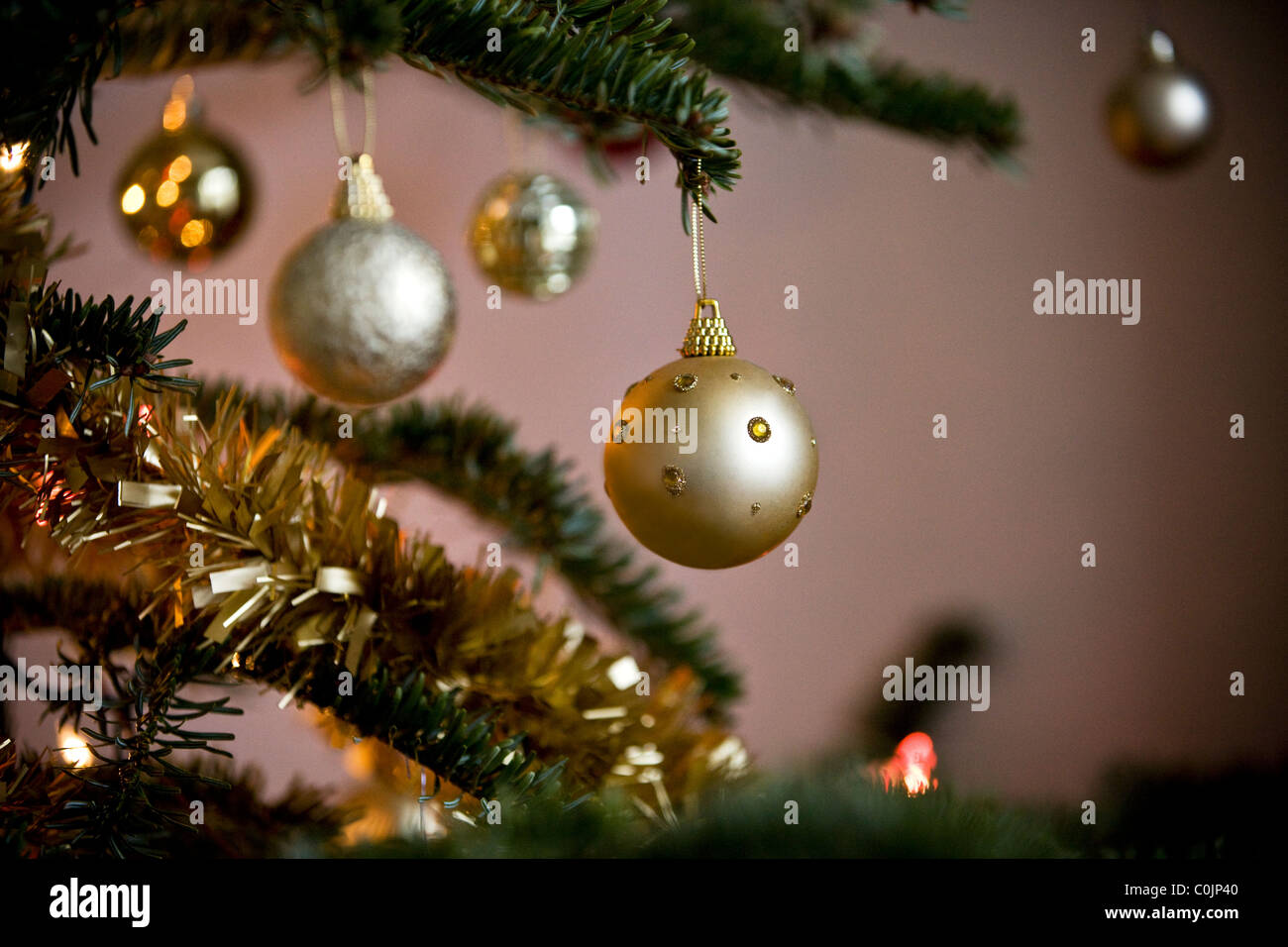 Gold baubles hanging on a Christmas tree Stock Photo